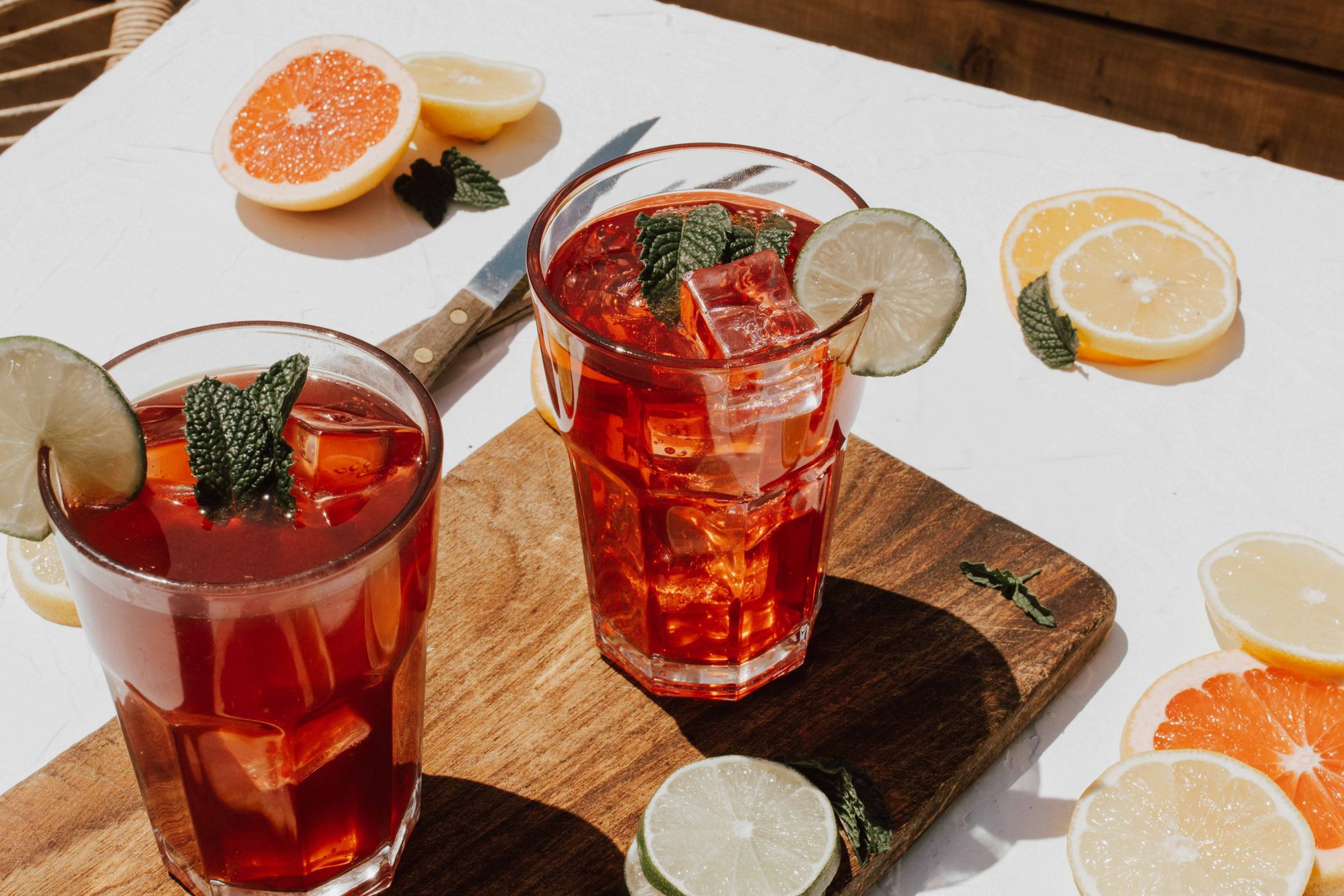 Helpot drinkit kotona – vadelma & minttu drinkki isossa lasissa. Ympärillä sitrushedelmiä.